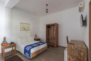 a bedroom with a bed and a table in it at Resort Fazenda 3 Pinheiros in Engenheiro Passos