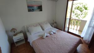 a bedroom with a bed with two towels on it at Apartmani Val in Donji Karin