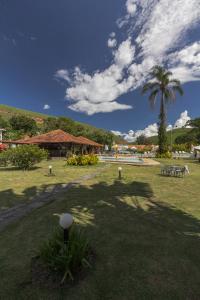 a park with a palm tree and a building at Resort Fazenda 3 Pinheiros in Engenheiro Passos
