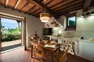 a kitchen with a wooden table and a large window at Castellina di Bocco in Castiglion Fibocchi