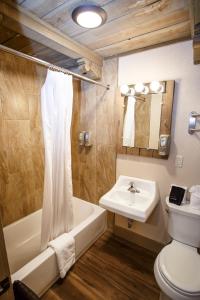 uma casa de banho com um lavatório, uma banheira e um WC. em Chama Trails Motel em Chama