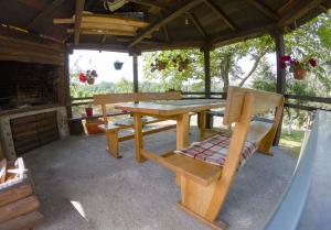 a wooden picnic table and bench in a pavilion at Apartments Vesna in Slunj