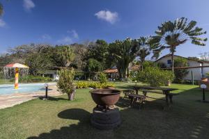 a park with a picnic table and a pool at Resort Fazenda 3 Pinheiros in Engenheiro Passos