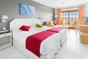 a bedroom with two beds and a living room at Elba Castillo San Jorge & Antigua Suite Hotel in Caleta De Fuste