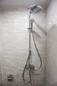 La salle de bains est pourvue d'une douche avec un pommeau de douche. dans l'établissement White Central Apartment, à Varna