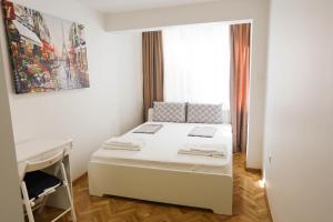 - une petite chambre avec un lit et un bureau dans l'établissement White Central Apartment, à Varna
