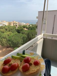 einen Teller mit Lebensmitteln mit Tomaten und Gemüse auf dem Balkon in der Unterkunft Casa Cometa - vista mare in Monopoli