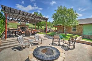 a patio with chairs and a table and a fireplace at Charming Hilltop Cottage in Medicine Park! in Medicine Park