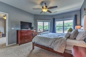 a bedroom with a bed and a flat screen tv at Idyllic Camdenton Condo with Community Pool and Lake! in Camdenton