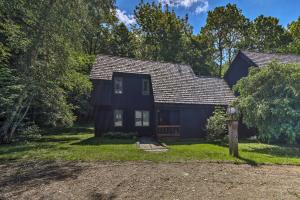 a black house with a porch and a yard at Rustic Waitsfield Condo about 1 Mi to Hike and Ski! in Waitsfield