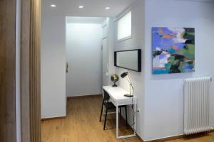 Camera bianca con una scrivania con lampada e un quadro. di LightHouse 17 a Salonicco