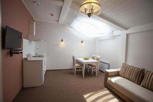 a living room with a couch and a table and a kitchen at Hotel Litera in Dnipro