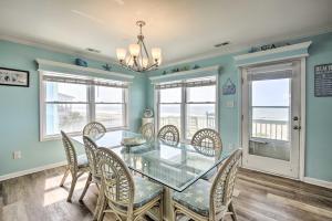 a dining room with a glass table and chairs at Large-Group Getaway - Beachfront Home with Pool! in Holden Beach