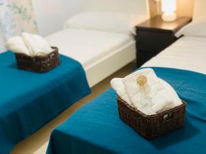 two baskets of towels are sitting on two beds at M & B Beach Apartment in Valencia +39 photos