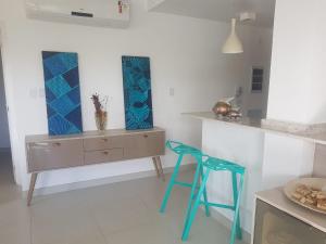 a kitchen with a blue stool and a counter at Praia do Forte- Iberostar- Ap Luxuoso 3 qts in Mata de Sao Joao