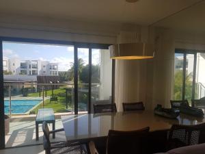 a dining room with a table and a view of a pool at Praia do Forte- Iberostar- Ap Luxuoso 3 qts in Mata de Sao Joao