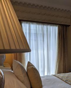 a bed with pillows in front of a window at Foley's Townhouse Killarney in Killarney