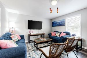 uma sala de estar com um sofá azul e uma televisão em The Flamingo House em Ocean City