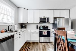 a kitchen with white cabinets and a sink and a stove at The Flamingo House in Ocean City