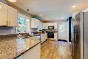 a kitchen with white cabinets and a stainless steel refrigerator at The Beached Whale in Wells