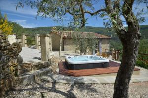 una bañera de hidromasaje en un patio con un árbol en Fonte Comelia, en Cortona
