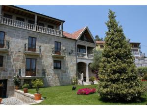 a large stone building with a christmas tree in the yard at Casa Antiga Do Monte in Lestrove