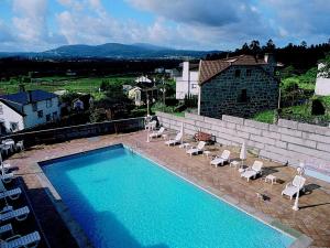 a large swimming pool with lounge chairs and a building at Casa Antiga Do Monte in Lestrove