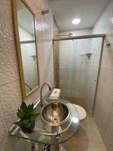 ein Badezimmer mit Waschbecken, Toilette und Spiegel in der Unterkunft Casa Maragogi in Maragogi