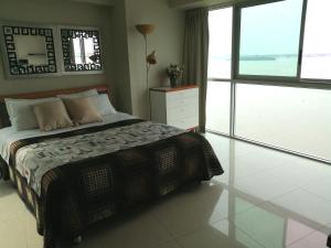 a bedroom with a bed and a large window at River View Suites Guayaquil in Guayaquil