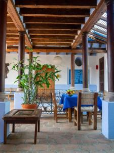 un patio con mesa, sillas y una planta en Hotel Boutique La Batucada en Valle de Bravo