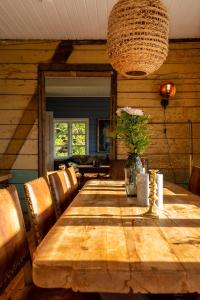 un tavolo in legno con sedie e un vaso di fiori di Villa Borgvåg - A unique Seafront Villa in the heart of Lofoten a Bøstad