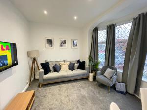 uma sala de estar com um sofá e duas cadeiras em Ivy Apartments by CityNest em Blackpool