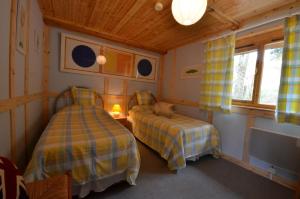 TreignacにあるWoodlands Cottageのベッドルーム(ベッド2台、テレビ付)