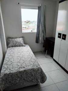 une chambre avec un lit, une fenêtre et un bureau dans l'établissement Apartamento aconchegante no Jardim Paulistano, à Campina Grande
