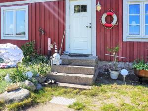 a red house with stairs leading to a door at 6 person holiday home in S LVESBORG in Sölvesborg