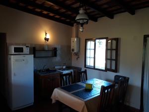 cocina con mesa y nevera blanca en Las Achiras, Casas de Campo en Federación