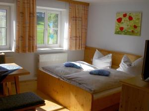 1 dormitorio con cama de madera y 2 almohadas en Urlaub am Bauernhof Wenigeder - Familie Klopf en Gutau