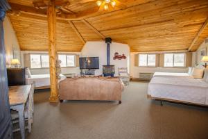 a bedroom with two beds and a tv in a room at Chama Trails Motel in Chama