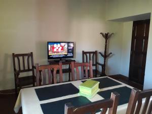 a dining room with a table with a television and a tableablish at Las Achiras, Casas de Campo in Federación