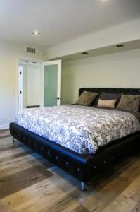 ein Schlafzimmer mit einem großen Bett mit schwarzem Rahmen in der Unterkunft Tranquility in Prime Location with Private Pool in Los Angeles
