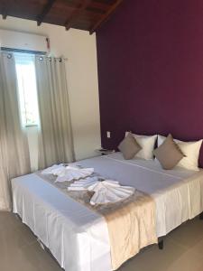 a bedroom with two beds with white sheets and a window at Foca Guest House in Búzios
