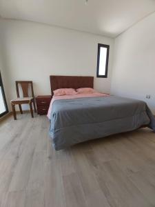 1 dormitorio con 1 cama y suelo de madera en Plage des nations bouknadel sale, en Sale