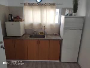 uma pequena cozinha com um lavatório e um frigorífico em גני התניא em Safed