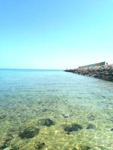 una gran masa de agua con rocas y arrecifes en Il sole, en Maruggio