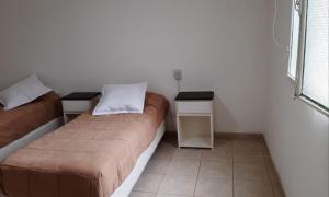 Una pequeña habitación con dos camas y una ventana. en Q255 - Dpto PB zona residencial en Neuquen, en Neuquén