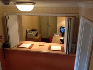 einen Schreibtisch mit einem Spiegel im Zimmer in der Unterkunft Ashley Hotel in Cambridge