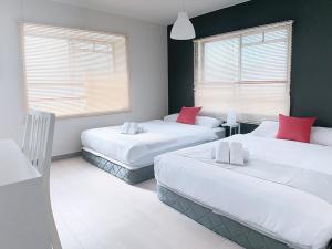 a bedroom with two beds with red pillows at OUCHI HOTEL Kanayama-cho with Dogs in Hiroshima