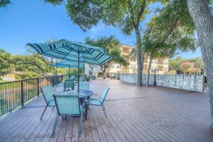 eine Terrasse mit einem Tisch, Stühlen und einem Sonnenschirm in der Unterkunft Ripley River Haus IC 302 in New Braunfels