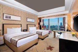 Habitación de hotel con 2 camas y TV en Wyndham Grand Plaza Royale Colorful Yunnan, en Kunming