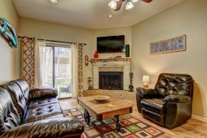 a living room with leather furniture and a fireplace at Go With The Flow CW B103 in New Braunfels